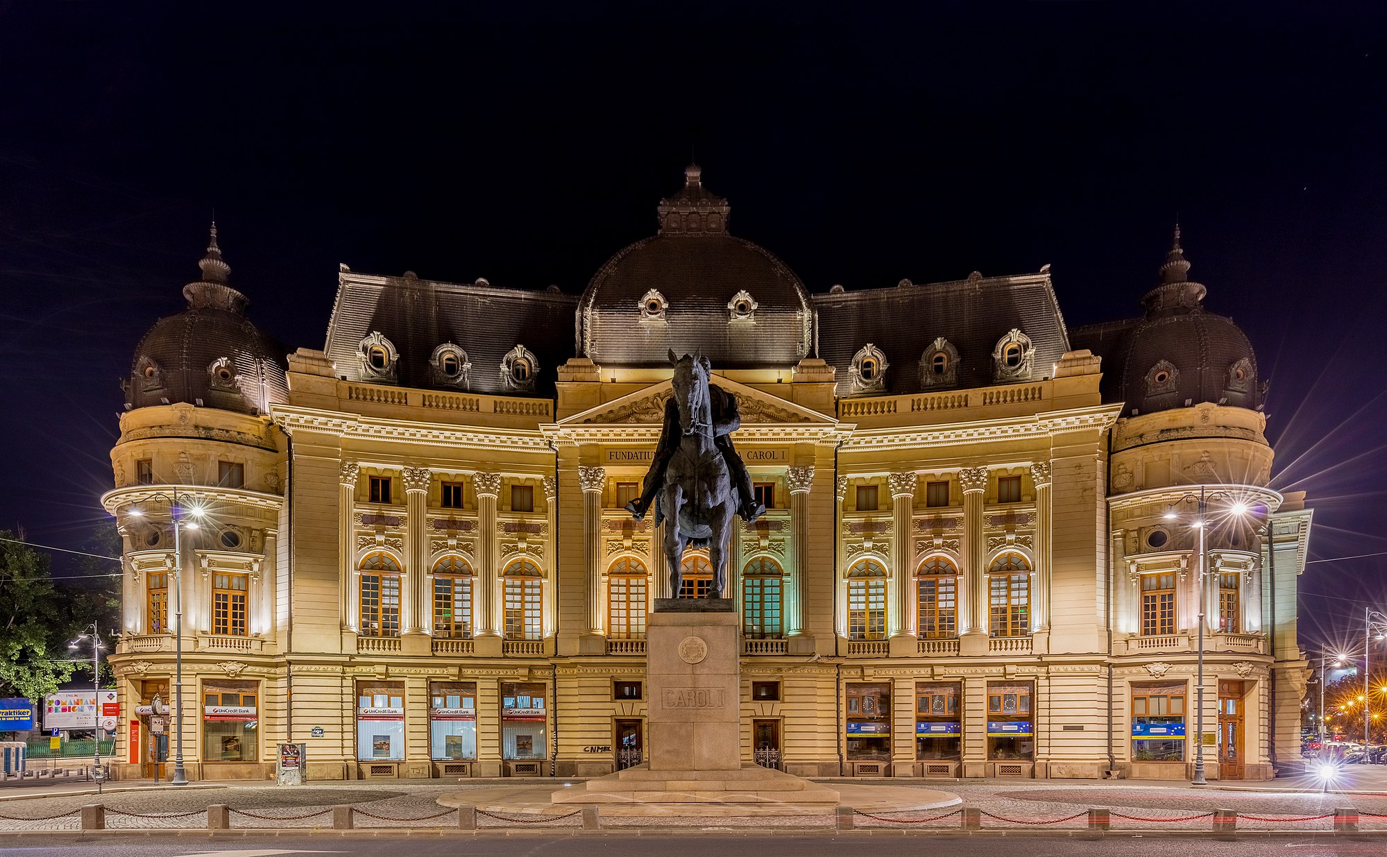 Frontal view of the Central University Library of Bucharest and Carol I statue, Bucharest, Romania. The Central University Library was founded in 1895, 31 years after the foundation of the University of Bucharest, as the Carol I Library of the University Foundation. The building, designed by French architect Paul Gottereau, was completed in 1893 and opened on 14 March 1895. The volume collection has grown steadily from 3,400 volumes in 1899 to over 2 million in 1970.