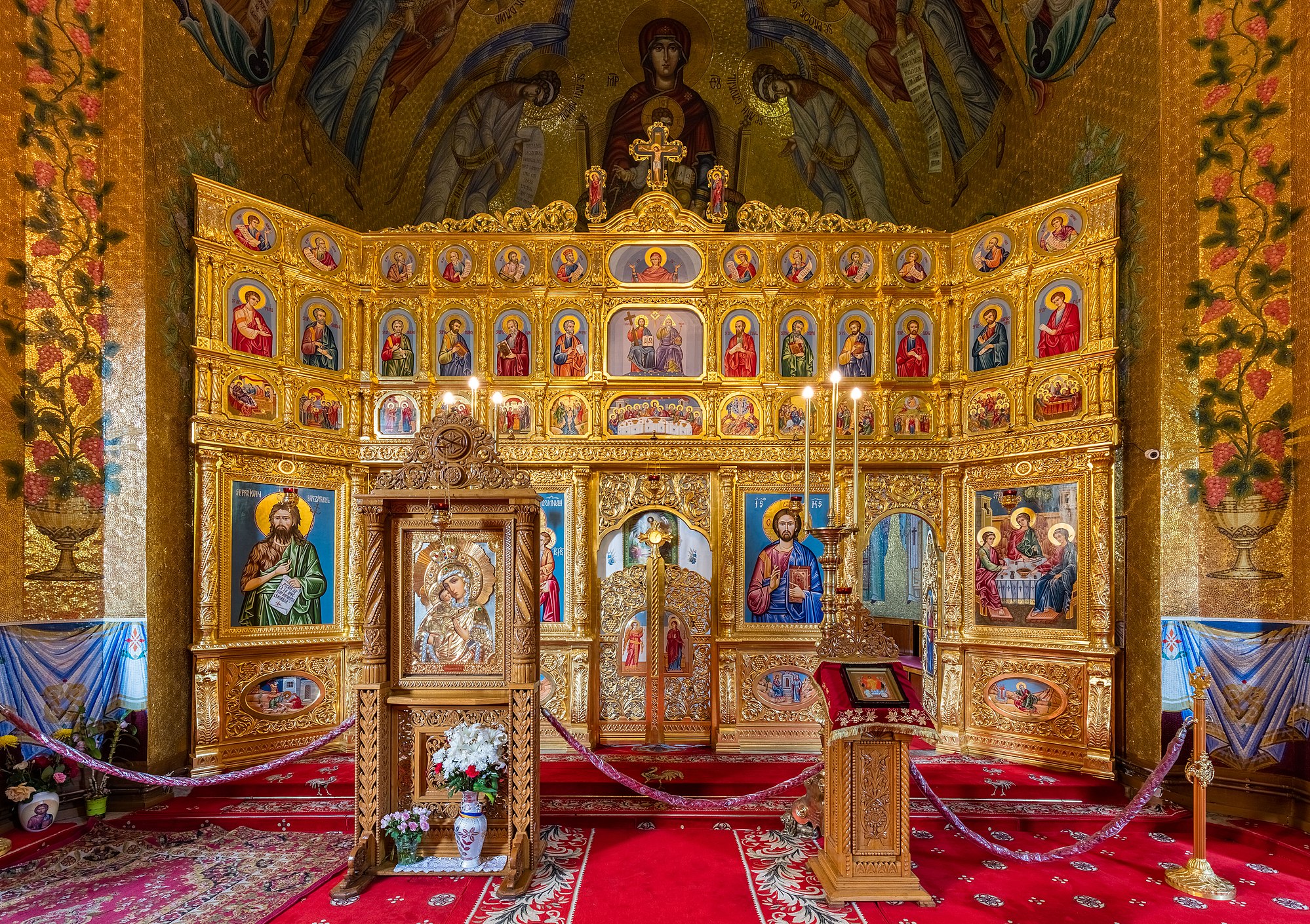 Iconostasis in the church of the Cocoș Monastery, Romania. The monastery, located in a forest clearing 6 kilometres (3.7 mi) from Niculițel, was built between 1883 and 1913 and is dedicated to the Dormition of the Theotokos.