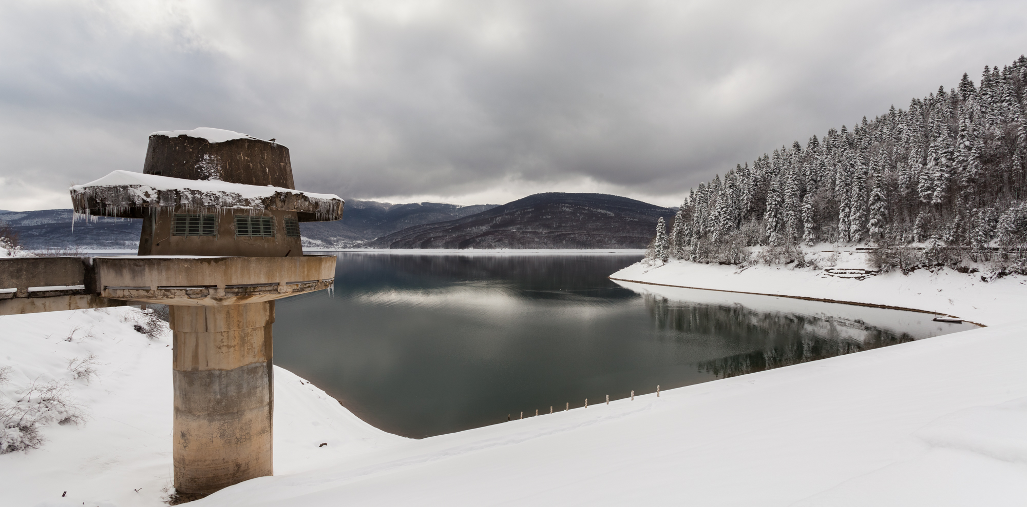 Winter scene of the watching tower, dam and Mavrovo Lake, Mavrovo National Park, Republic of Macedonia. The park, founded in 1949, is the largest (of the three existing) in the country with 780 km2, while the lake has a length of 10 km and a width of 5 km.