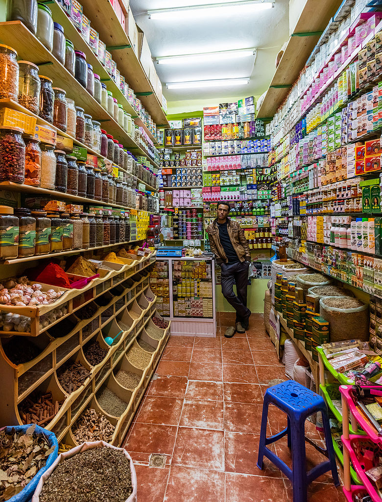 Seller posing in a grocery and cosmetics shop in Grand Socco, Tangier, Morocco.
