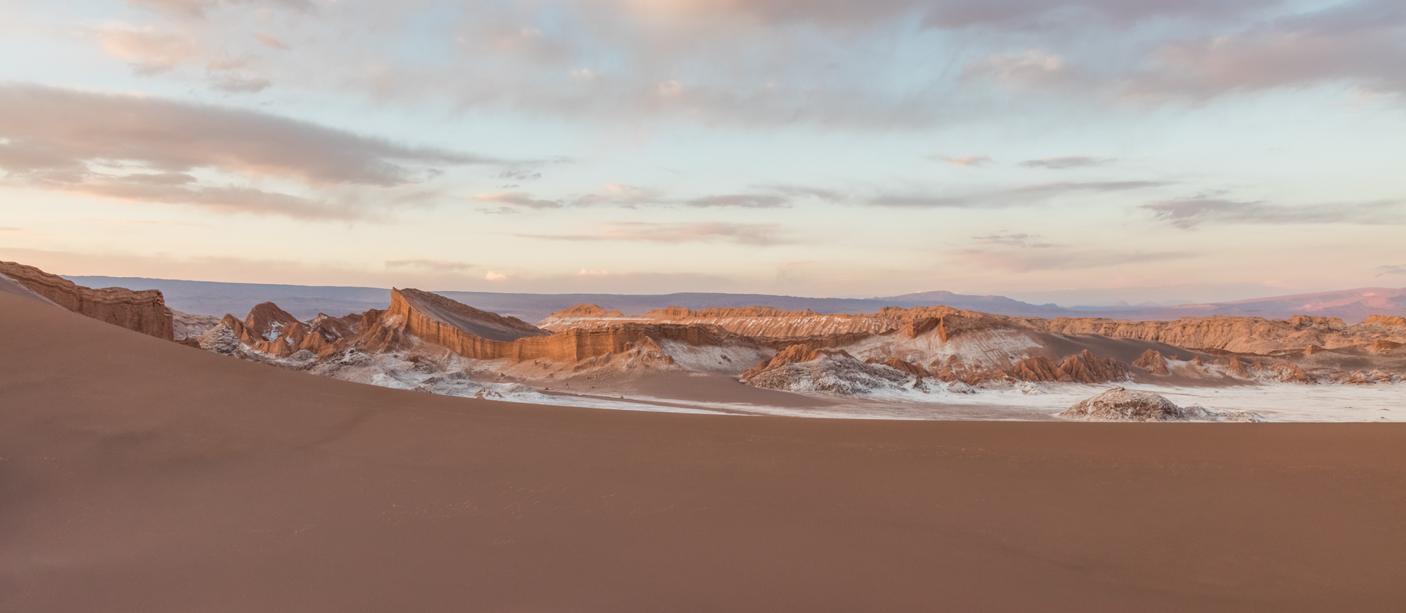 View at dusk of two of the highlights in Valle de la Luna, the Great Dune in the foreground, and the Amphitheater in the background, San Pedro de Atacama, northern Chile.