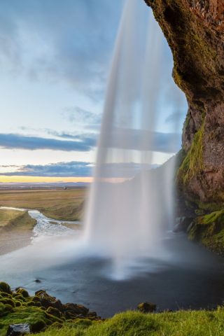 Lateral view of the Seljalandsfoss waterfall during a sunset, Suðurland, Iceland.