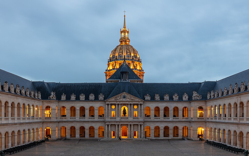 Courtyarrd ("Cour d'honneur") of Les Invalides, Paris, France. Les Invalides is a complex of buildings located in the 7th arrondissement of Paris containing the Musée de l'Armée, the military museum of the Army of France, the Musée des Plans-Reliefs, and the Musée d'Histoire Contemporaine. The complex also includes the former hospital chapel, now national cathedral of the French military, and the adjacent former Royal Chapel known as the "Dôme des Invalides", the tallest church building in Paris at a height of 107 metres (351 ft) (display here in the background of the image). The latter has been converted into a shrine of some of France's leading military figures, most notably the tomb of Napoleon.